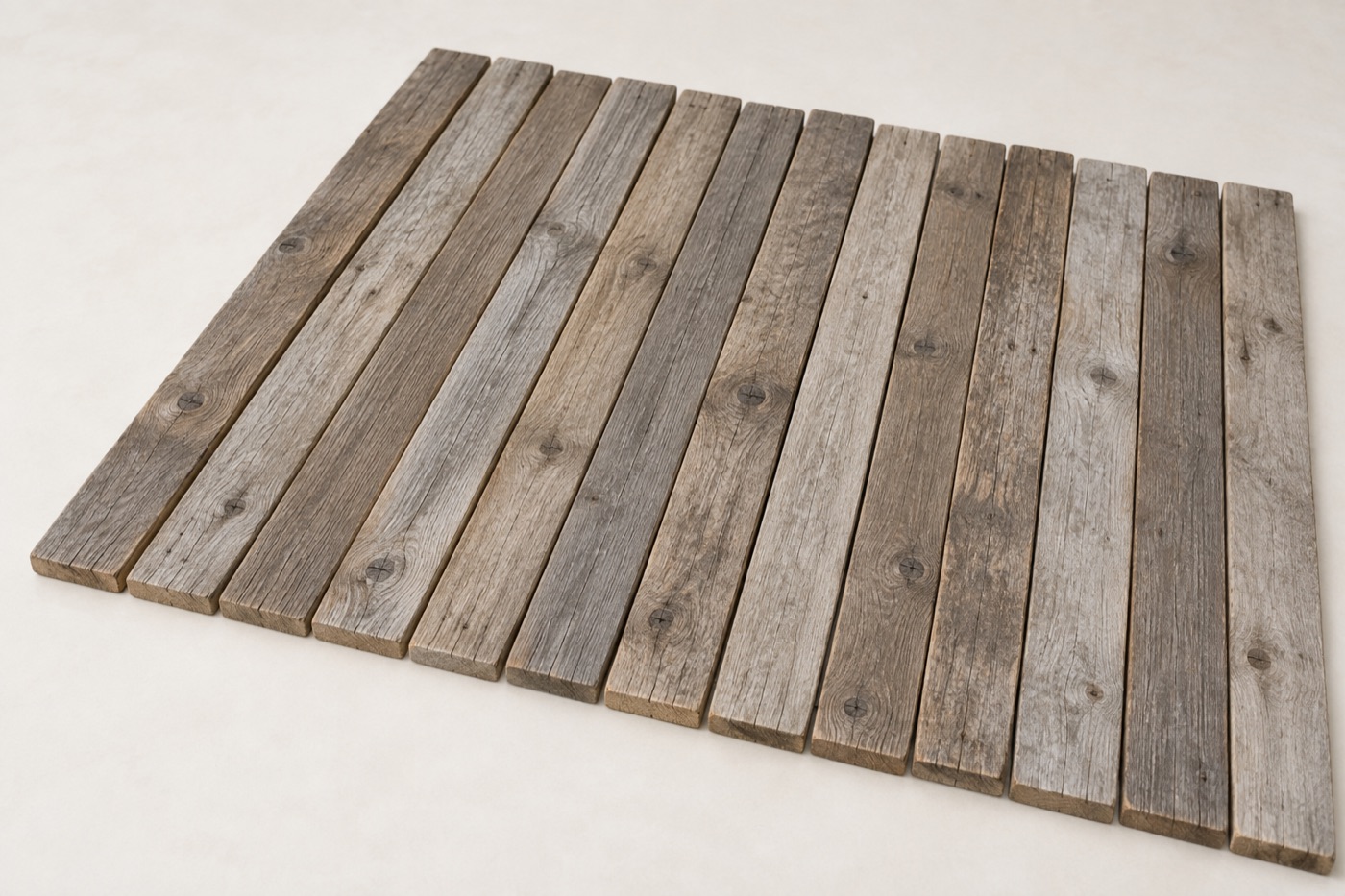 Weathered reclaimed timber boards with silvered grey surfaces, open grain and fine surface cracking
